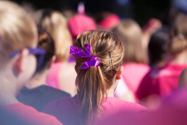 Women in pink shirt and ponytail tied in ribbon