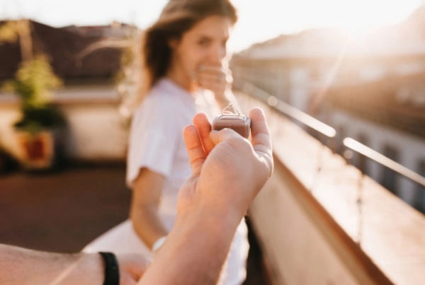 Man holds engagement ring up to girlfriend